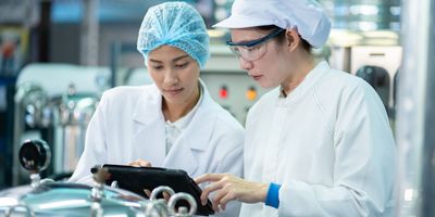 Food safety team reviewing documentation and test results in a laboratory setting, representing collaborative validation in alternative protein testing