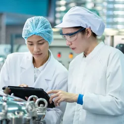 Food safety team reviewing documentation and test results in a laboratory setting, representing collaborative validation in alternative protein testing