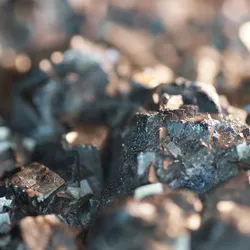 Close-up of a mineral matrix with sharp-edged crystals, illustrating the type of complex solid sample that can be analyzed using dual-laser mass spectrometry.