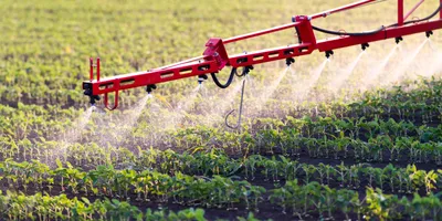 Spraying equipment applies herbicides across a crop field, representing a key stage in agricultural practices relevant to herbicides analysis.
