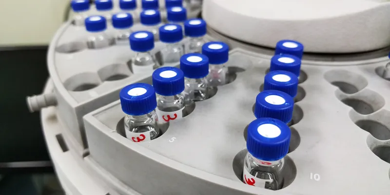 HPLC troubleshooting for purine peak issues, shown by autosampler vials used in reversed-phase liquid chromatography analysis.
