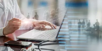Scientist reviewing GMP documentation on a laptop, with digital folder icons representing secure and traceable data management in a regulated lab setting.