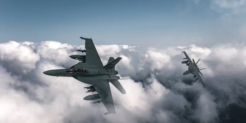 Two military fighter jets flying above the clouds during a mission related to jet fuel testing, showcasing real-time aerial analysis capabilities.
