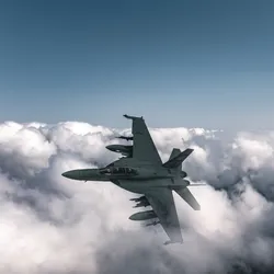 Two military fighter jets flying above the clouds during a mission related to jet fuel testing, showcasing real-time aerial analysis capabilities.