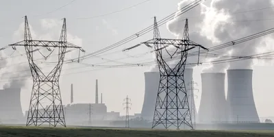 Cooling towers and high-voltage power lines at a nuclear power plant, illustrating how radiochemical analysis supports the safe production of electricity from nuclear energy for the power grid.
