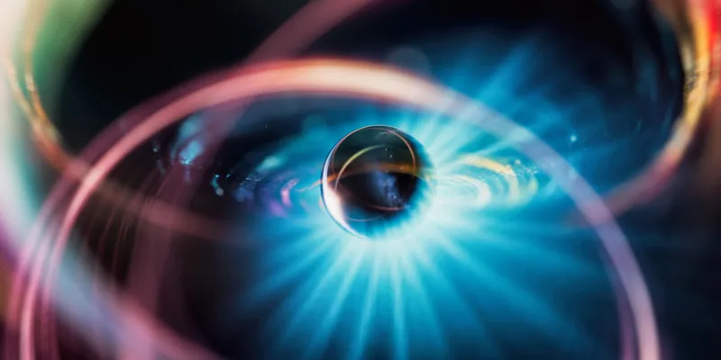 Visualization of atomic structure with glowing electron orbits, symbolizing isotopic differentiation and mass-to-charge separation principles used in isotope ratio mass spectrometry for nuclear chemistry applications.