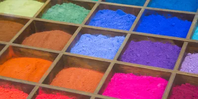 Pigment characterization of dry color powders displayed in segmented trays for comparative evaluation of composition and appearance.