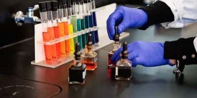 Colorful test tubes arranged in a rainbow pattern representing pigment diversity in laboratory analysis, aligned with ASTM safety standards.
