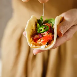 Woman squeezing lime over a taco, illustrating the importance of flavor perception and sensory experience in the development and consumer acceptance of alternative protein products.