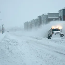 Snow plough removing snow from street