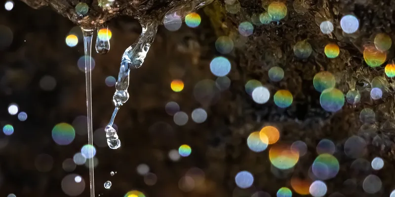 Close-up of a liquid chromatography system with stainless steel tubing and subtle chromatogram overlay, symbolizing precise separation of ultra-short PFAS compounds.