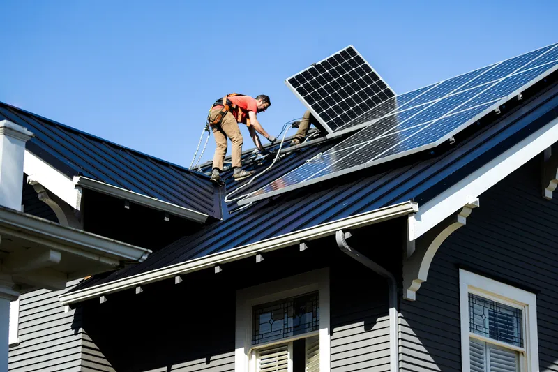 Technician examining solar panels in a lab to evaluate durability, polymer degradation, and trace metals as part of solar panel life cycle analysis and renewable energy testing.