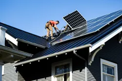 Technician examining solar panels in a lab to evaluate durability, polymer degradation, and trace metals as part of solar panel life cycle analysis and renewable energy testing.