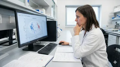 A scientist in a laboratory analyzes a PCA Score Plot on a computer screen, illustrating the use of chemometrics in biotech and pharma for data interpretation.