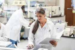 Chemist analyzing data in a lab with HPLC equipment