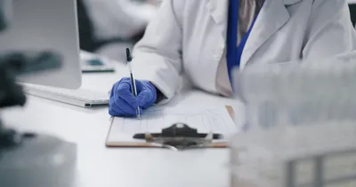 Scientist taking notes on bimiralisib oncology drug