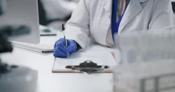 Scientist taking notes on bimiralisib oncology drug