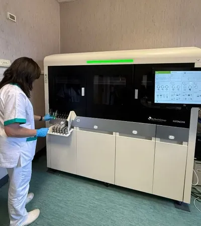 Technician operating MyGenius PRO high-throughput molecular diagnostics system