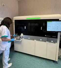 Technician operating MyGenius PRO high-throughput molecular diagnostics system