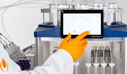 Scientist demonstrating Biotage PrepXpert 8 with a gloved hand pointing to screen.