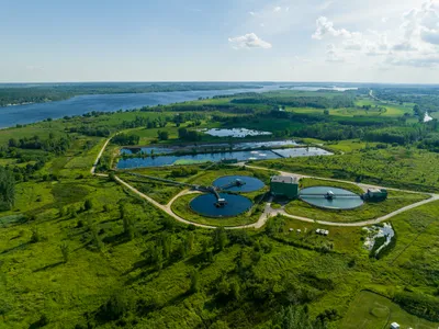 Aerial view of a wastewater treatment plant surrounded by green landscapes.