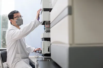 Scientist adjusting gas chromatography equipment for alternative carrier gases