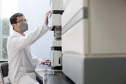 Scientist adjusting gas chromatography equipment for alternative carrier gases