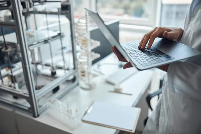 Digital lab transformation: Scientist with laptop and lab instruments