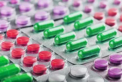 Assorted capsules and tablets representing materials in extractables and leachables testing