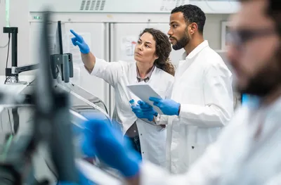 Researchers reviewing LC/MS data in a lab