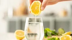 Squeezing lemon into a glass of water