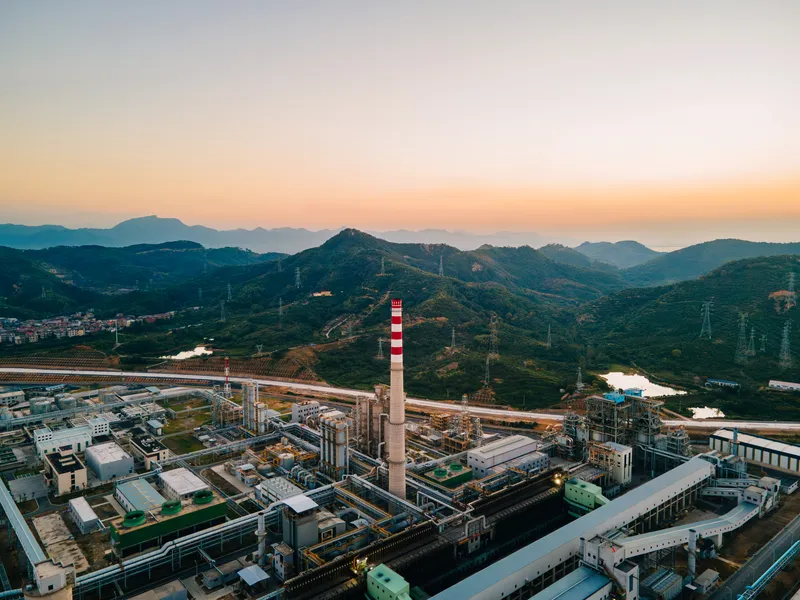 Industrial landscape with fuel processing plant and mountainous background