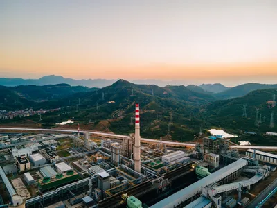 Industrial landscape with fuel processing plant and mountainous background