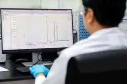 Scientist analyzes mass spectrometry data on a computer