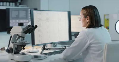 Scientist analyzing data on a computer, pivotal in automated and AI-enabled workflows.