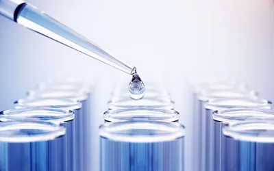 Pipette dropping liquid above test tubes for ASTM D3606 GC standards