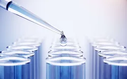 Pipette dropping liquid above test tubes for ASTM D3606 GC standards