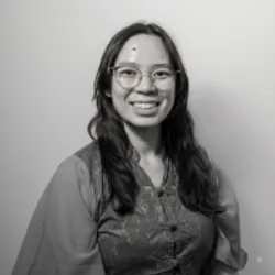 black and white photo of Sharon Dong in a button up blouse, smiling