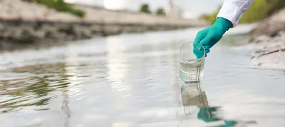 Scientist taking water sample near factory