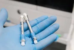 Hand holding LC-MS/MS columns for PFAS analysis