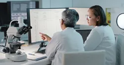 Laboratory staff reviewing PFAS data on computer screen