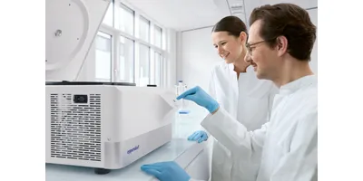 Two researchers in white lab coats and blue gloves operating the Eppendorf Centrifuge 5811 R control panel in a well-lit modern laboratory — a refrigerated centrifuge for multipurpose benchtop workflows.