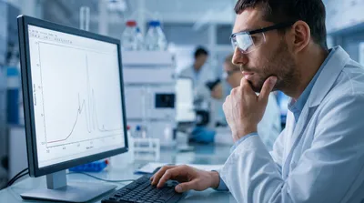 Laboratory technician reviewing chromatographic results from HPLC to UHPLC
