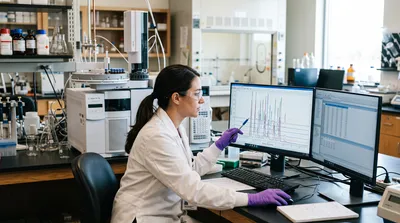An analyst examines gas chromatography retention time data on a laboratory workstation to identify compounds in a sample.