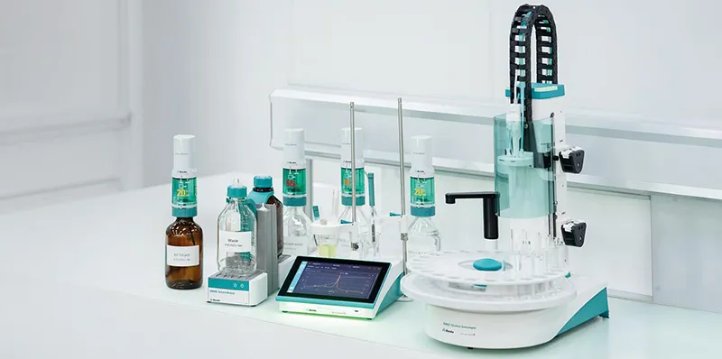 Metrohm IONIC Titrator system with touchscreen display, dosing burettes, reagent bottles, and sample changer for Karl Fischer titration on a white lab bench