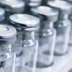 Glass vials for liquid samples. Laboratory equipment for dispensing fluid samples. Shallow depth of field.
