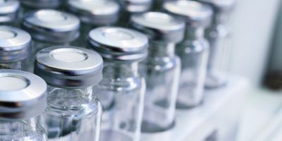 Glass vials for liquid samples. Laboratory equipment for dispensing fluid samples. Shallow depth of field.
